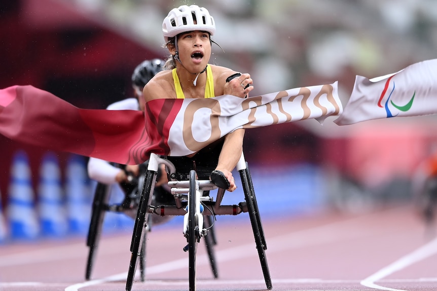 Woman cross the finish line to claim Paralympic gold in the women's marathon 