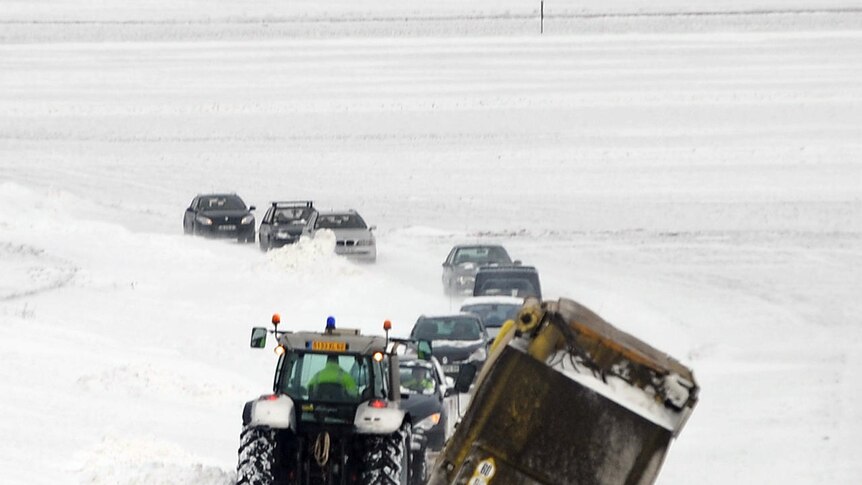 Heavy snowfall: a tractor removes a truck blocked by the snow near Arras in northern France.