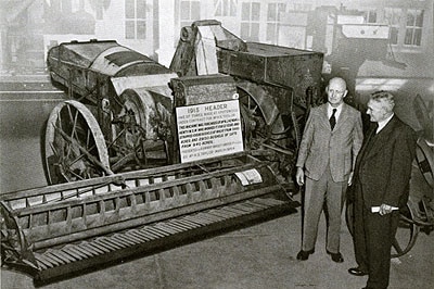 Headlie Taylor pictured in 1915 standing next to the Header he designed in 1914.