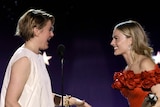 Greta Gerwig and Margot Robbit look at eachother excitedly. 