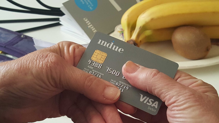 Person holding a cashless welfare card.