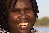 smiling woman in front of lake