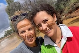 an image of two people smiling near water 