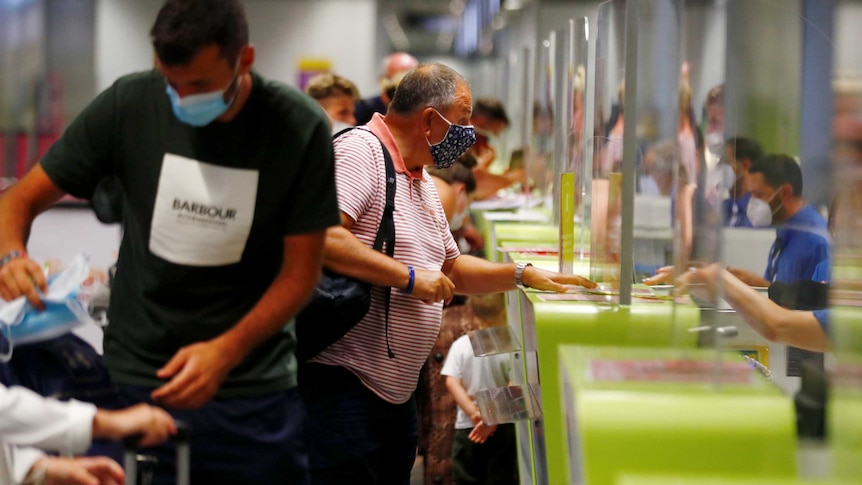 Man in black shirt wearing mask at airline counter