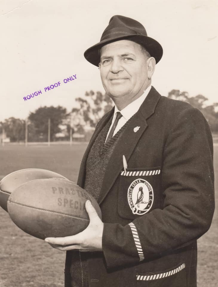 Old man in blazer booking at camera in black and white photo. 