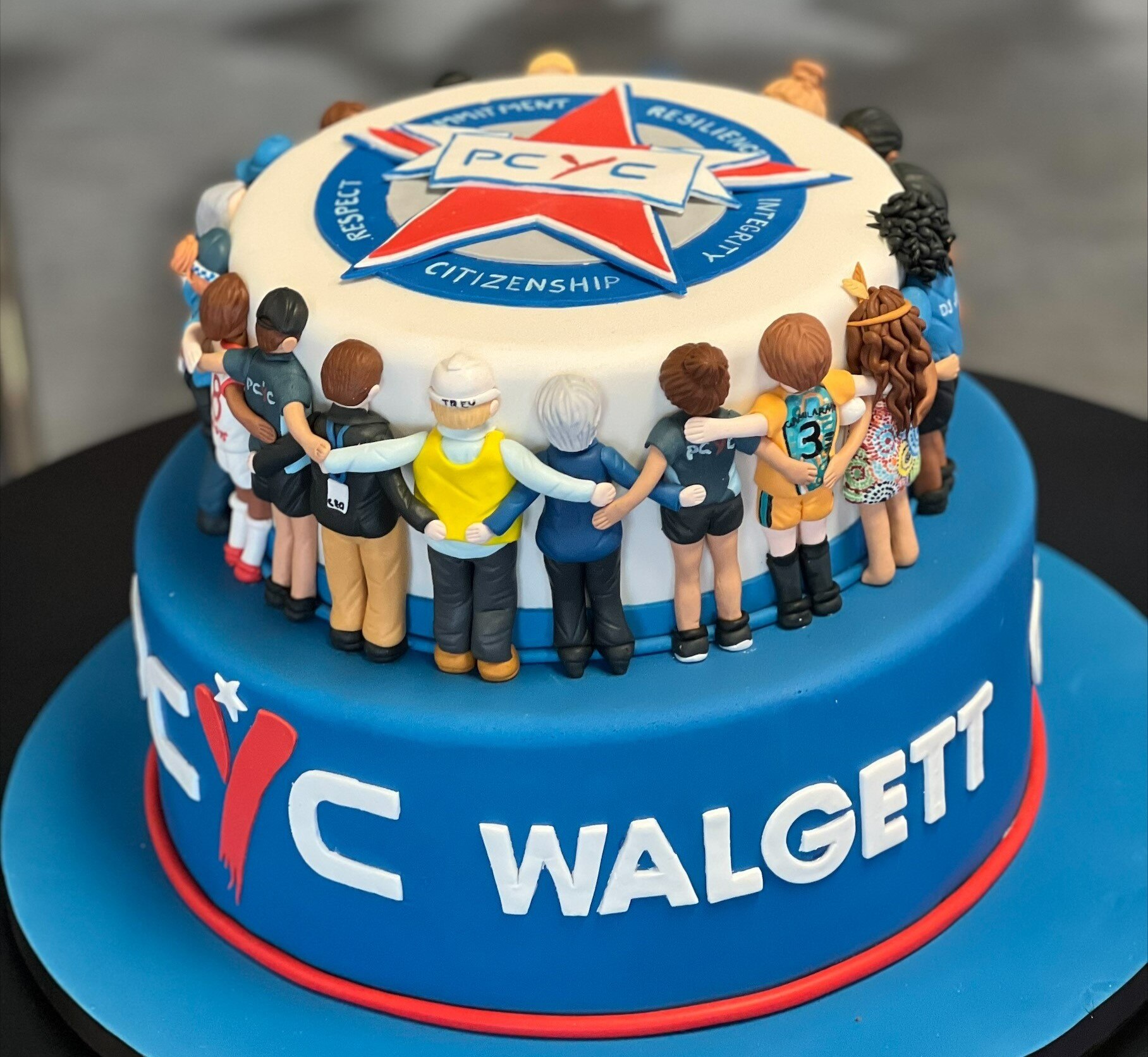 An eleaborately decorated cake with "PCYC Walgett" written on it in icing.