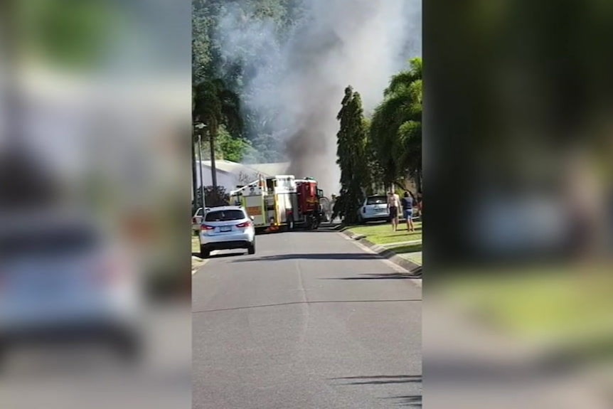 Footage shows smoke emerging from behind a firetruck at the end of a street