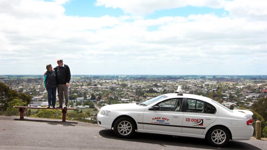 Two people with a taxi and skyline