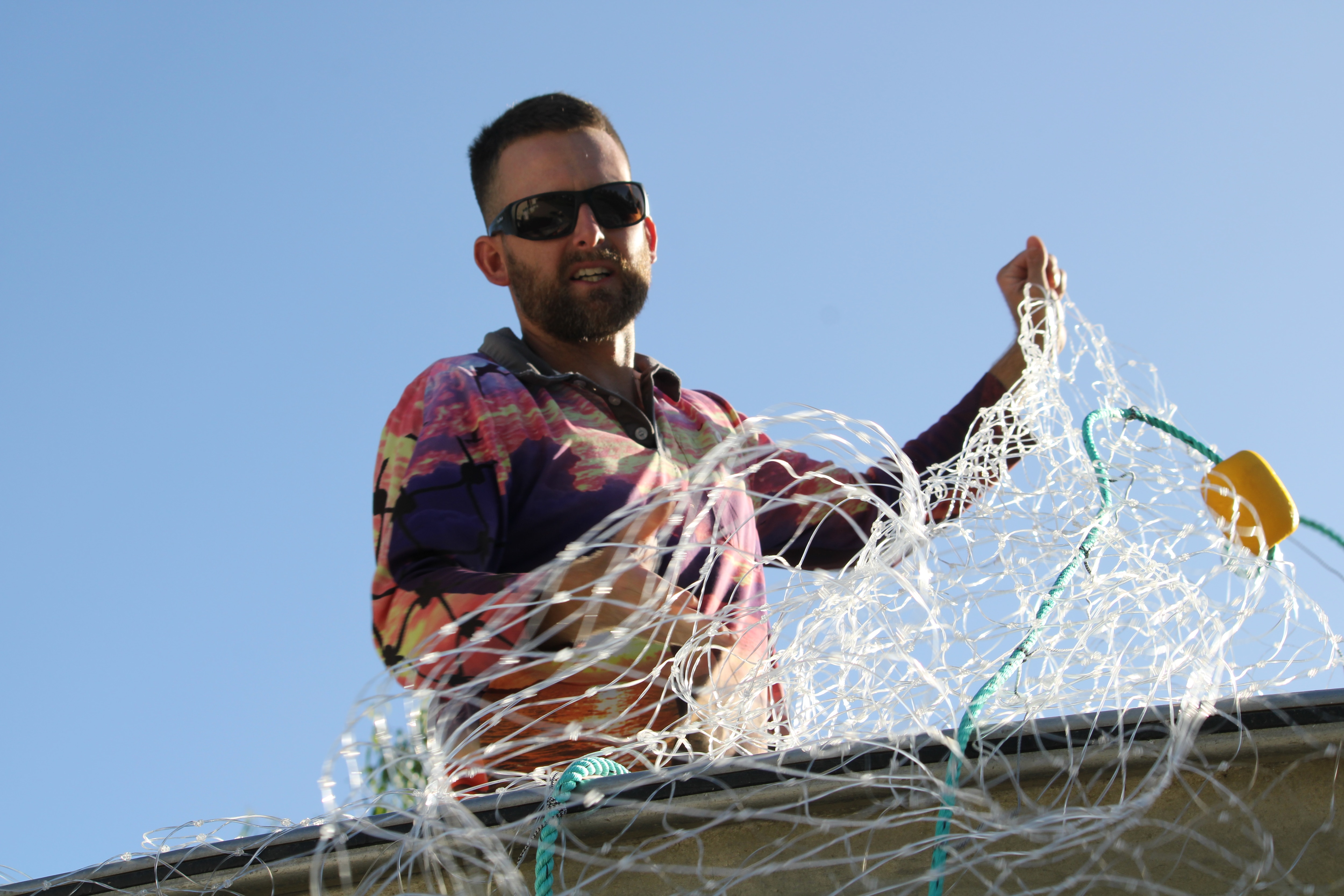 Un pescador mete una red de enmalle en su barco.