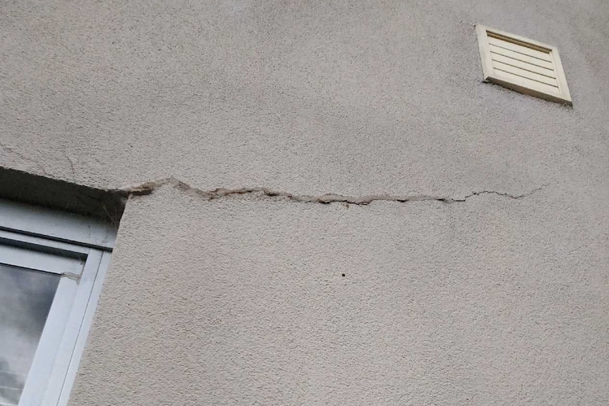 A crack in the corner of a window can be seen from the outside of an apartment complex.