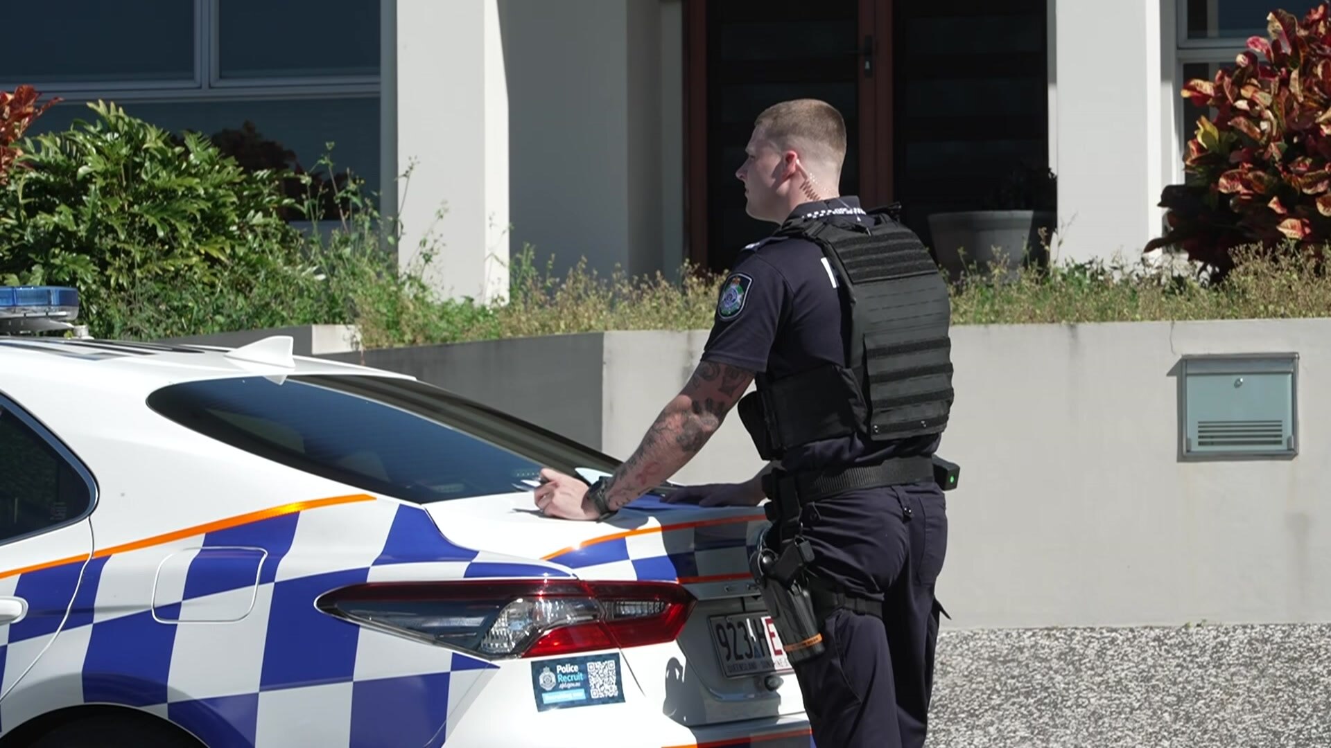 A police officer standing behind a police car