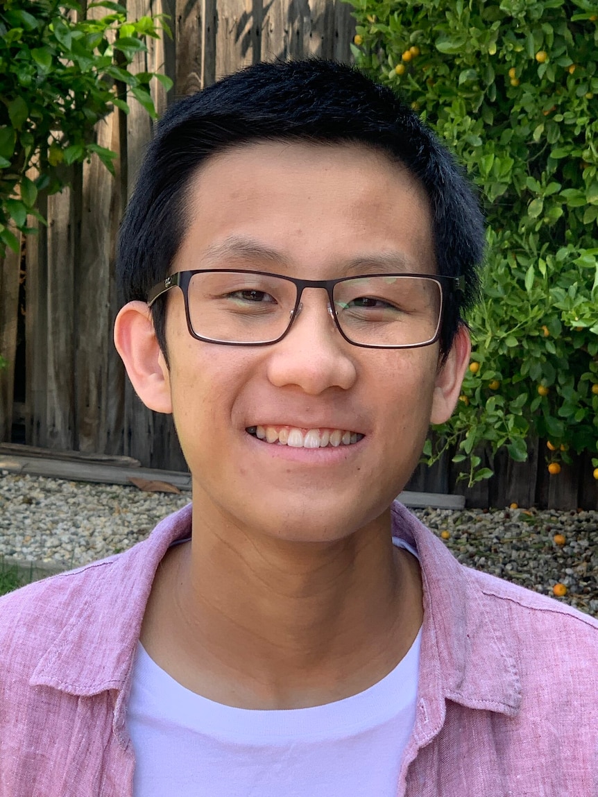 Headshot of a young Asian man wearing glasses