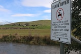 A sign next to Clyde River warning people not to drink the water. 