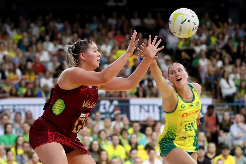 Cardwell waits with her arms in front as the ball comes to her, while Bruce is late to the contest with her arm out stretched