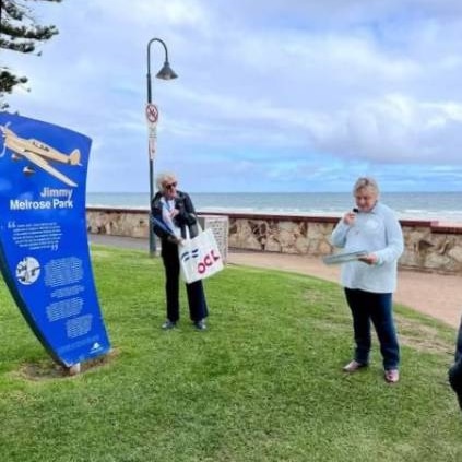 Two people stand in a park dedicated to aviator Jimmy Melrose.