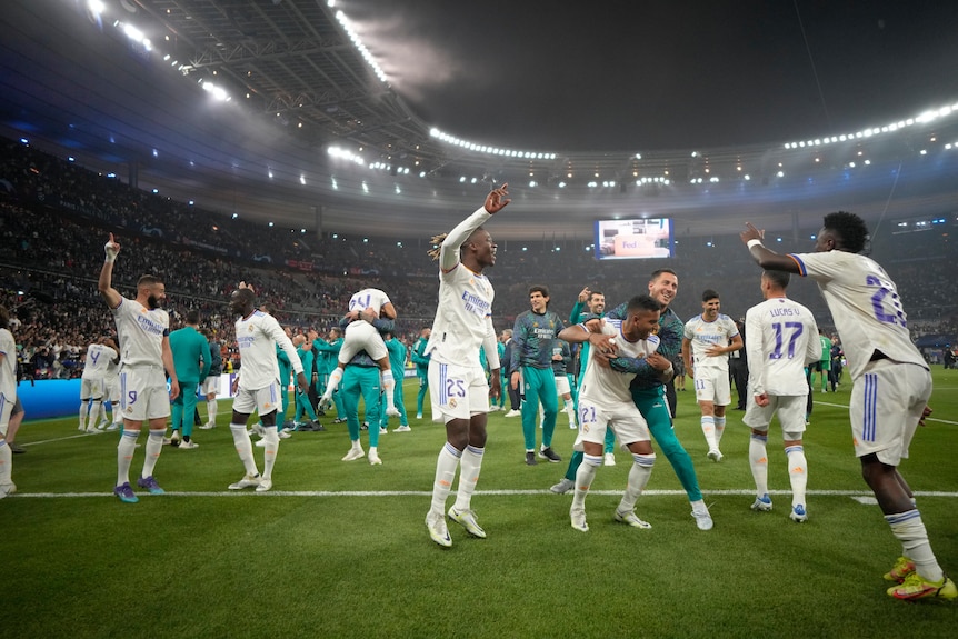 A group of Real Madrid players leap in the air and hug each other after the final whistle in the Champions League final. 