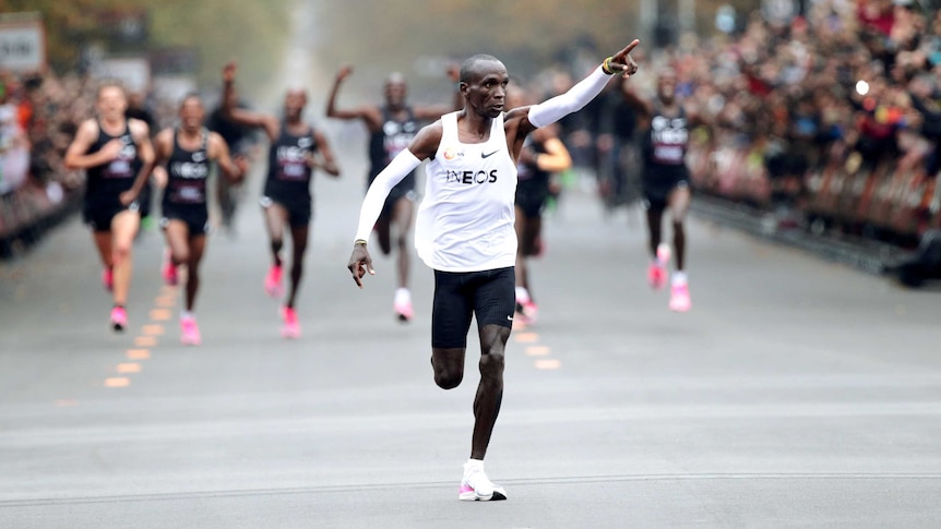 A Kenyan male athlete points his finger to the crowd as he approaches the finish line in a marathon in Vienna.