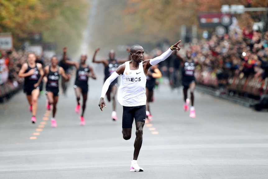 A Kenyan male athlete points his finger to the crowd as he approaches the finish line in a marathon in Vienna.