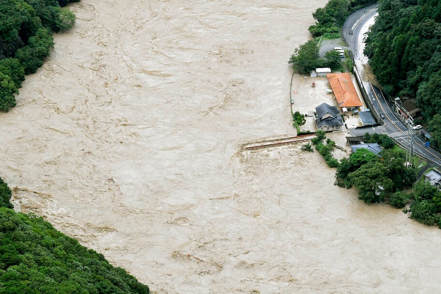 An aerial view of the bridge over the Kuma River shows the flood overwhelming its surroundings.
