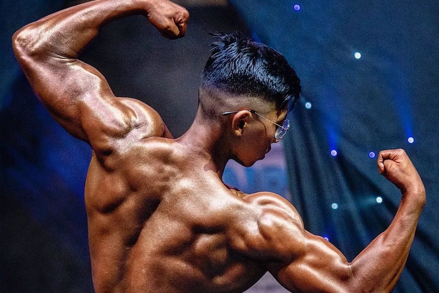 A man flexes at a competition