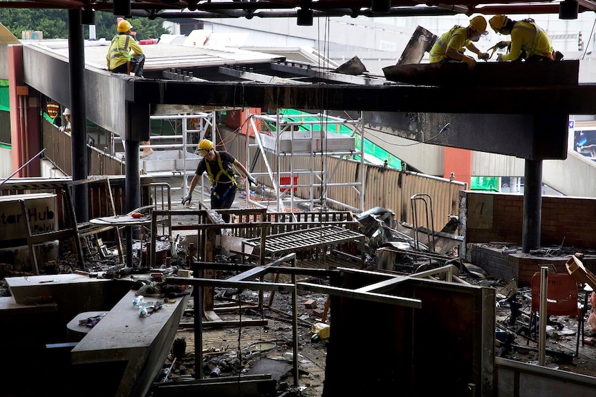 Workers repair damage to a pedestrian bridge near Hong Kong Polytechnic University.