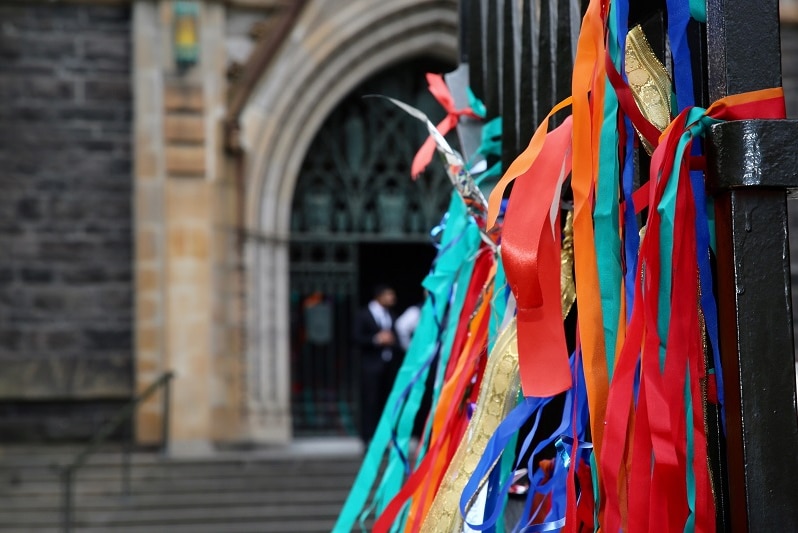 A row of colourful ribbons line a fence outside the entrance to St Patrick's Cathedral.