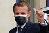 French President Emmanuel Macron gives the thumbs up while wearing a mask