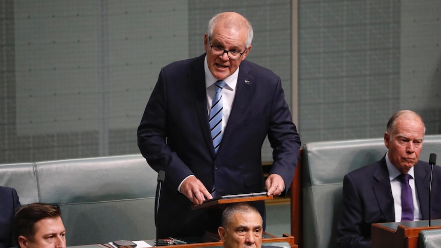 Morrison stands speaking from his seat in the house of representatives.