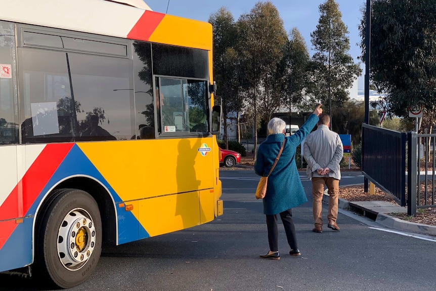 A bus next to two people