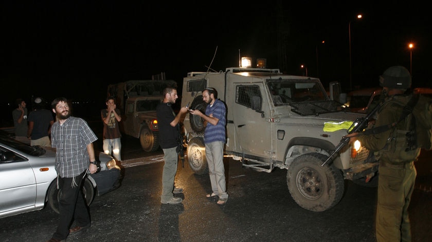 Jewish settlers stop at an Israeli army roadblock