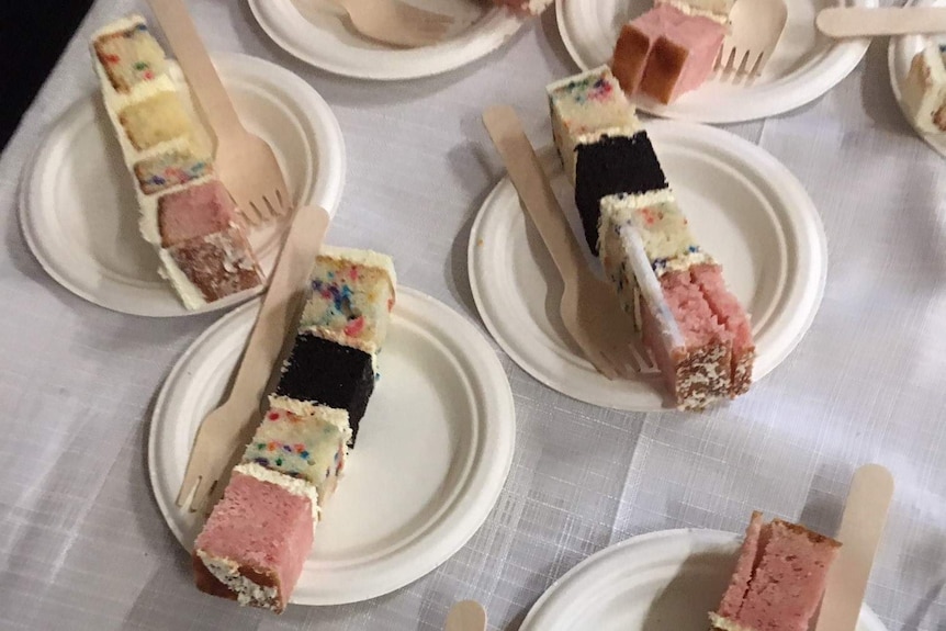 Slices of wedding cake served on paper plates, a homemade cake to feed a crowd.