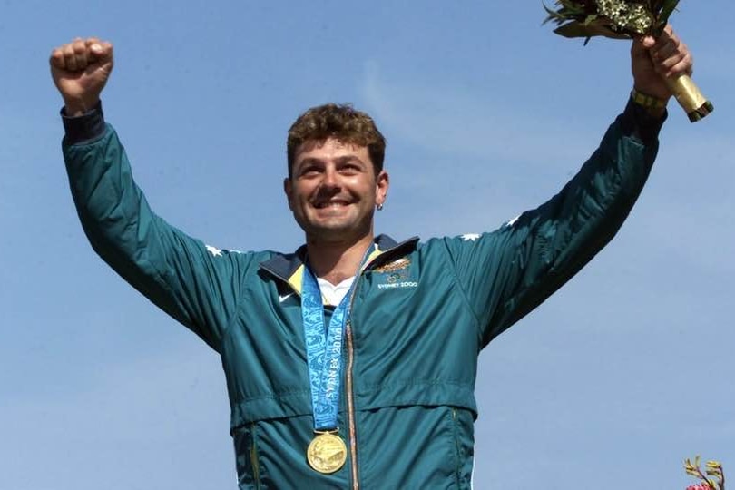 Man wearing gold medal and a green Australian top
