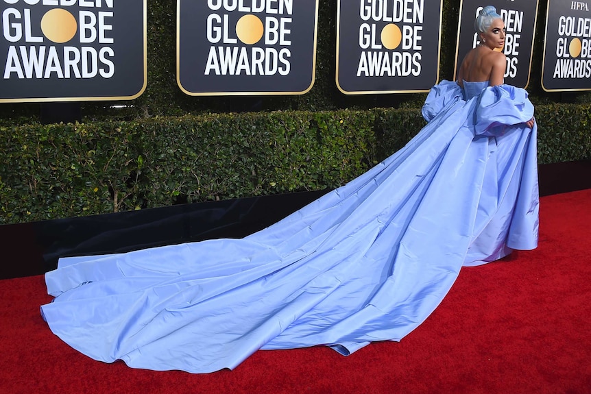 Lady Gaga wearing lavender gown with a long train and dramatic sleeves.