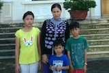 Vietnamese asylum seeker Tran Thi Lua stands together with her three children.