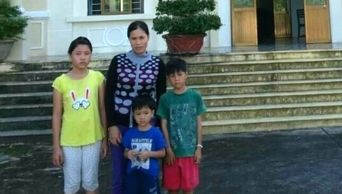 Vietnamese asylum seeker Tran Thi Lua stands together with her three children.