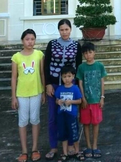 Vietnamese asylum seeker Tran Thi Lua stands together with her three children.