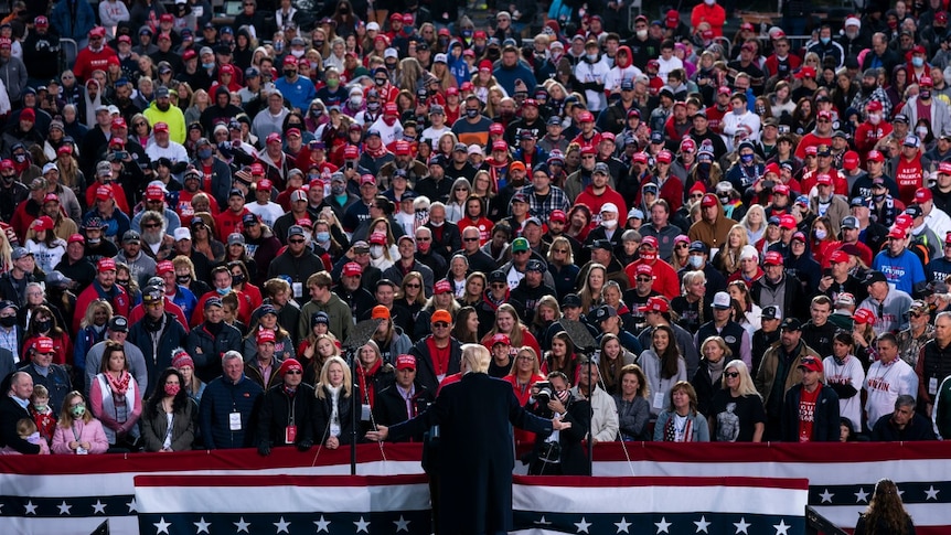 President Donald Trump speaks in front of a large crowd during a campaign rally