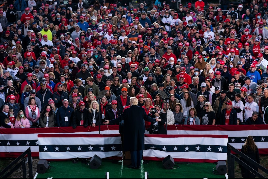 President Donald Trump speaks in front of a large crowd during a campaign rally