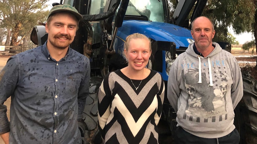 Alfie Jessop, Jess Mumford and dairy farmer Steve Dalitz standing in front of a tractor on a farm in northern Victoria.