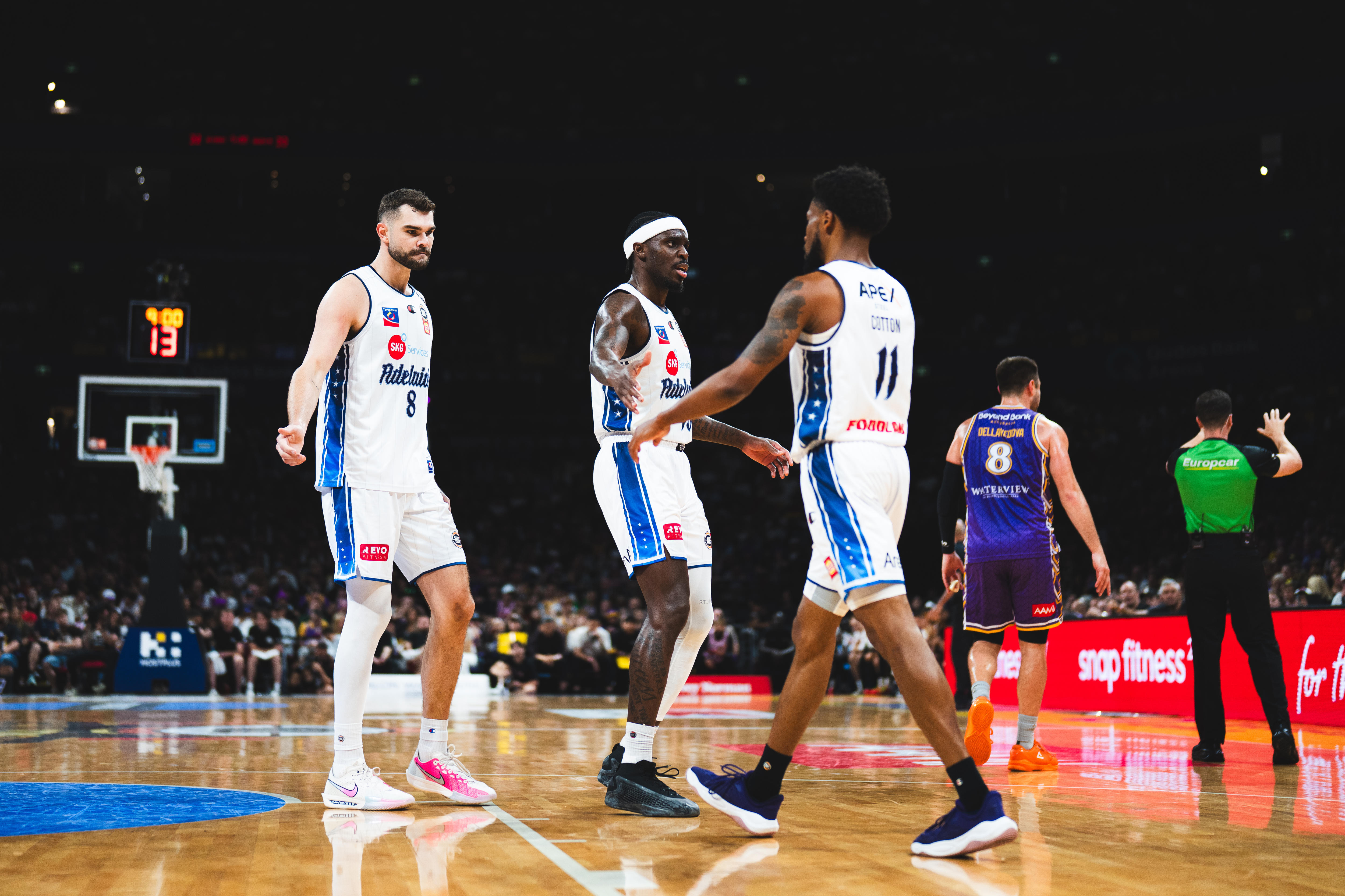 Three Adelaide 36ers players encourage each other during a match