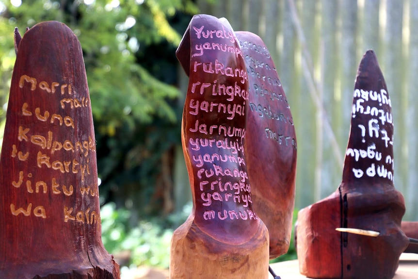 Wooden sculptures that look like tongues engraved with Aboriginal words in different colours.