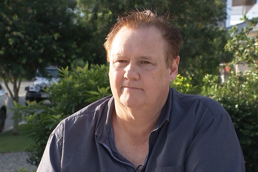 A Caucasian male, wearing a blue polo shirt, looking at the camera.