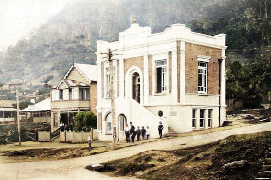 Photo depicts the Clifton School of Arts building in the 1900s. A few people stand outside.