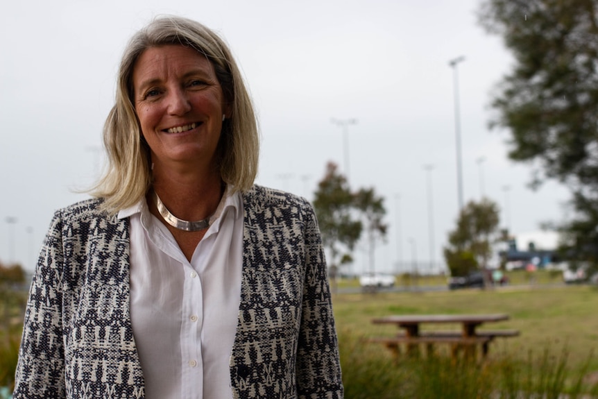 Robyn Seymour stands outside on a grey day smiling.