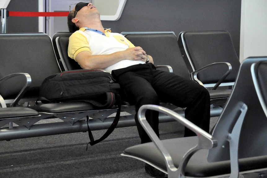 A traveller sleeps in Sydney Airport.