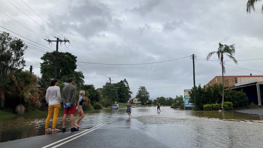 Billinudgel residents watching the flood waters rise down through the centre of the village with children playing in the water