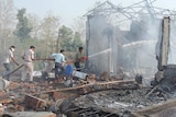 Rescuers hose down a building in India after an explosion.