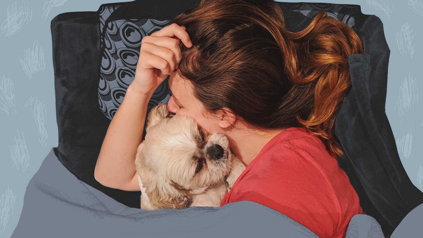 Kate Leaver lying down and cuddling her dog in a story about how to maintain your friendships through a difficult time