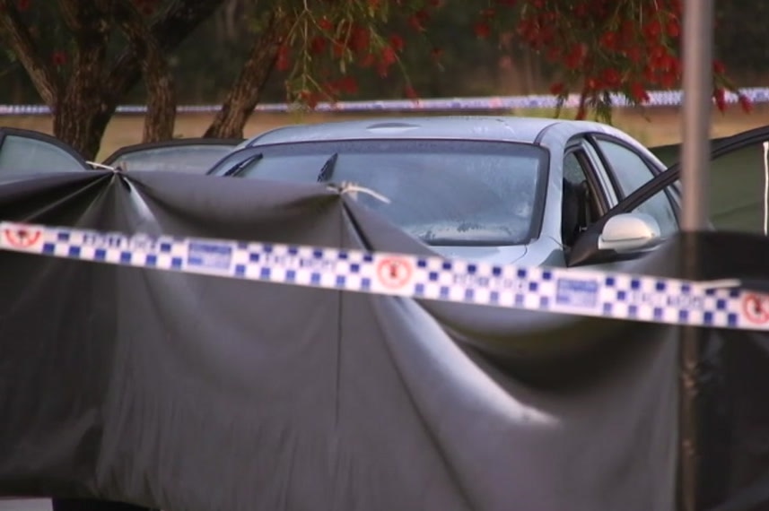 A car in front of police protective tape.