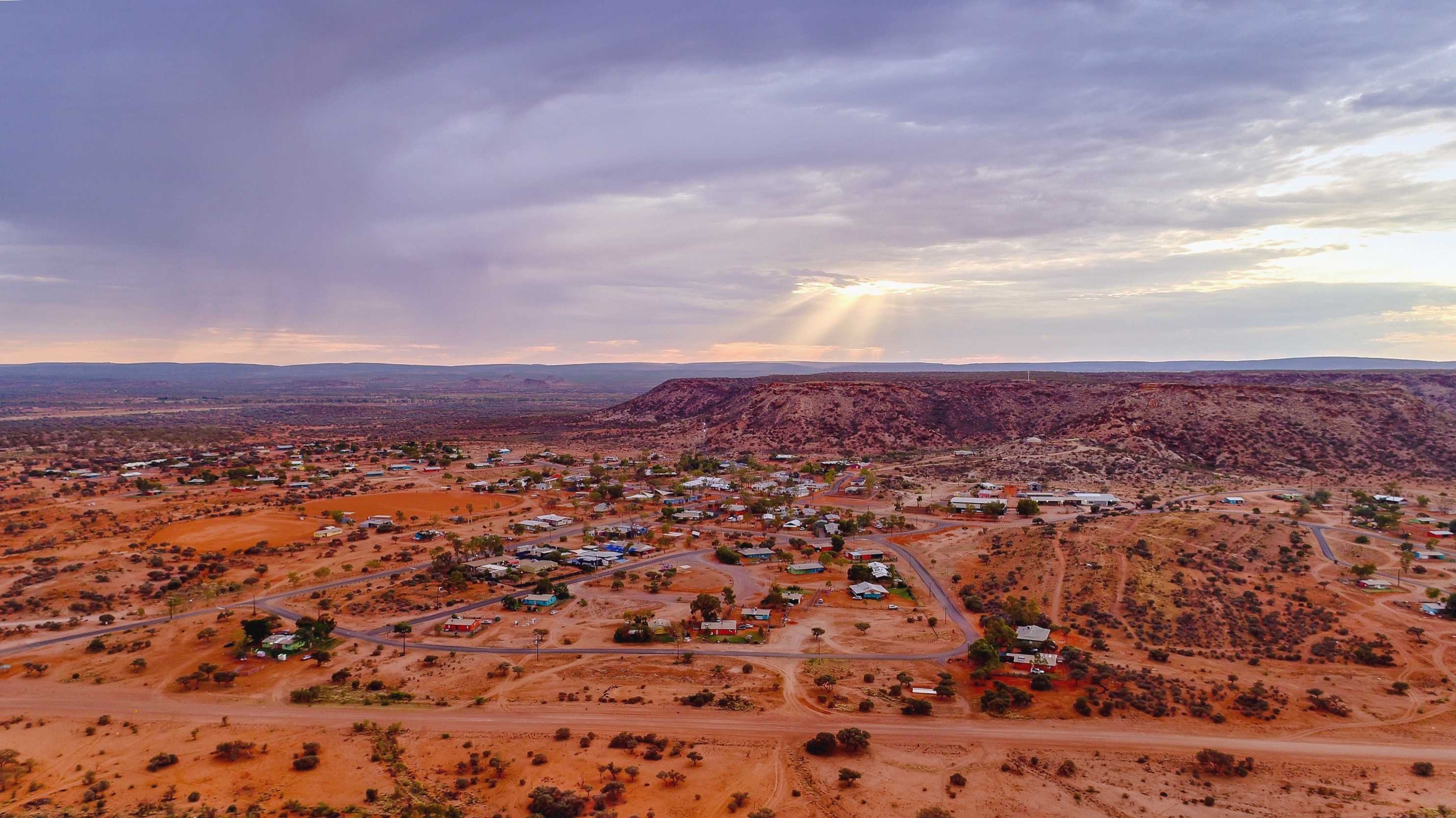 A cross stands on a hill above Santa Teresa as the sun rises.
